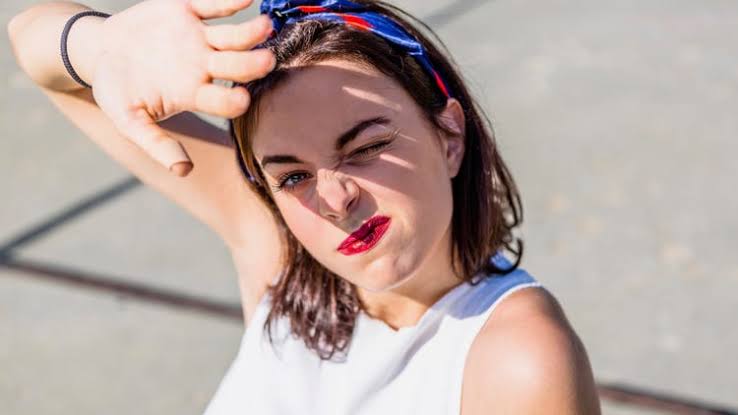 Girl covering the sunlight with her hand