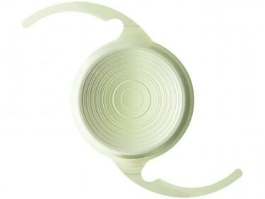 Pale green circular intraocular lens on a white background